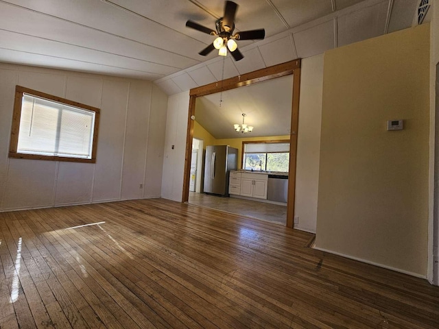 3546 Questa Dr, Los Alamos, NM 87544 - unfurnished living room featuring lofted ceiling, hardwood / wood-style floors, visible vents, and ceiling fan with notable chandelier