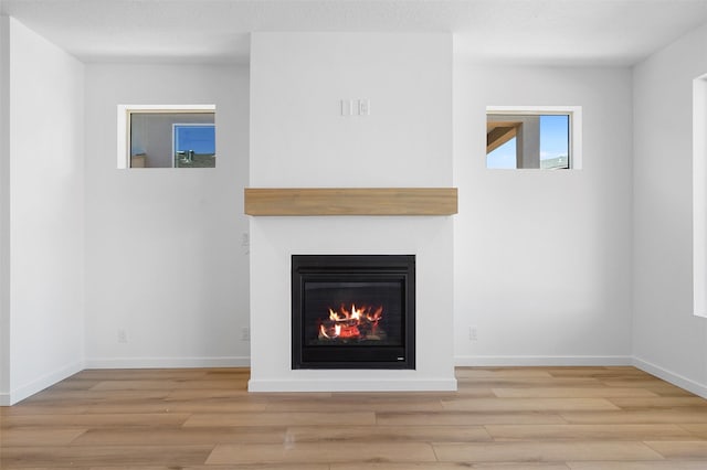 85 Cadena Blvd, Los Alamos, NM 87547 - unfurnished living room with wood finished floors, a glass covered fireplace, and baseboards