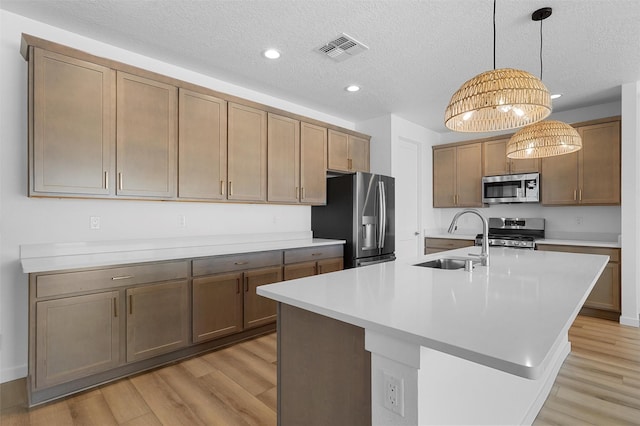 85 Cadena Blvd, Los Alamos, NM 87547 - kitchen with stainless steel appliances, a sink, light wood-type flooring, an island with sink, and recessed lighting