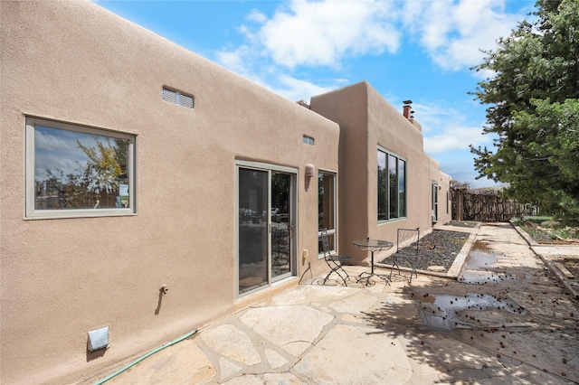 1 Azul Pl, Santa Fe, NM 87508 - back of house with stucco siding, a patio area, and a chimney