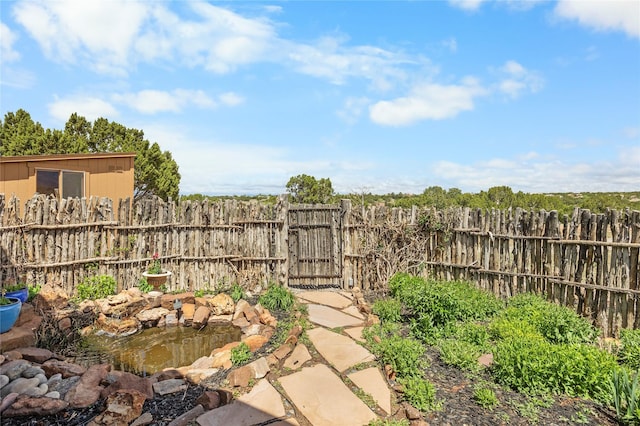 1 Azul Pl, Santa Fe, NM 87508 - view of yard featuring a garden pond and a gate