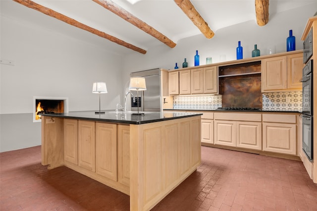 kitchen with a sink, beam ceiling, cooktop, built in fridge, and backsplash