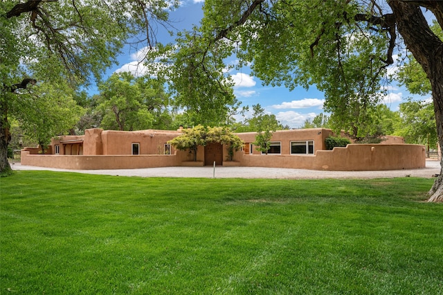 back of property featuring a yard and stucco siding