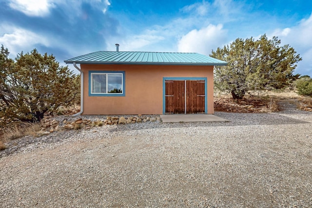 25A Lime Kiln Rd, Lamy, NM 87540 - rear view of house featuring stucco siding and metal roof