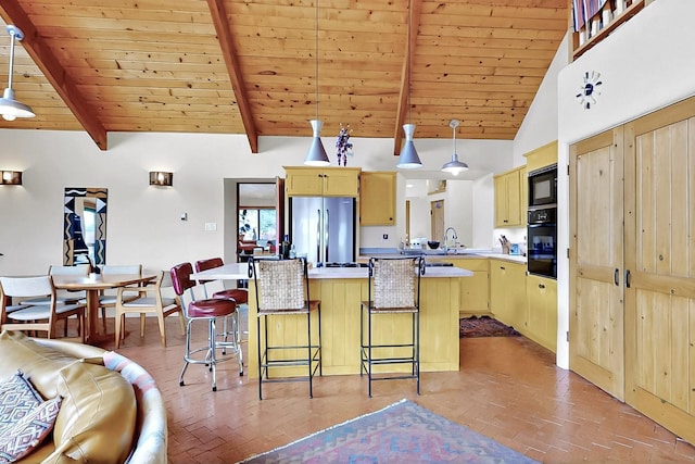 25A Lime Kiln Rd, Lamy, NM 87540 - kitchen featuring stainless steel fridge, brick flooring, black microwave, a breakfast bar, and wooden ceiling