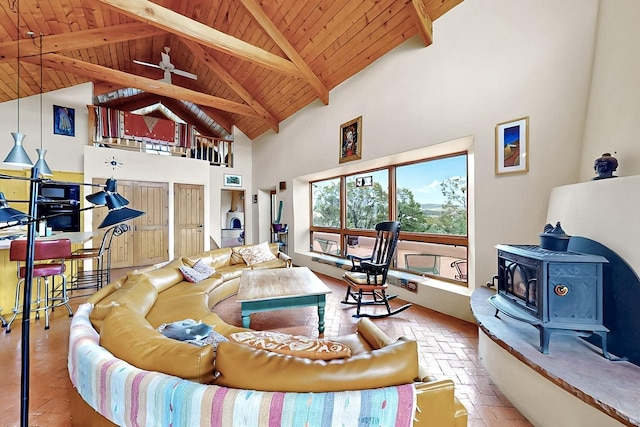 25A Lime Kiln Rd, Lamy, NM 87540 - living room featuring a wood stove, wooden ceiling, brick floors, high vaulted ceiling, and beam ceiling