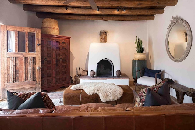 942 Canyon Unit A & B, Santa Fe, NM 87501 - living area featuring wood finished floors, beam ceiling, a fireplace with raised hearth, and track lighting