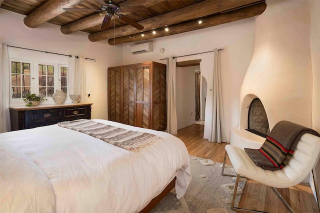 942 Canyon Unit A & B, Santa Fe, NM 87501 - bedroom with a wall mounted air conditioner, wood ceiling with exposed beams, and light wood finished floors
