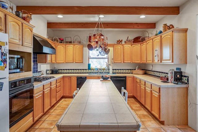 24 Camino Caballos Spur, Lamy, NM 87540 - kitchen featuring black appliances, beamed ceiling, tile counters, exhaust hood, and a kitchen island