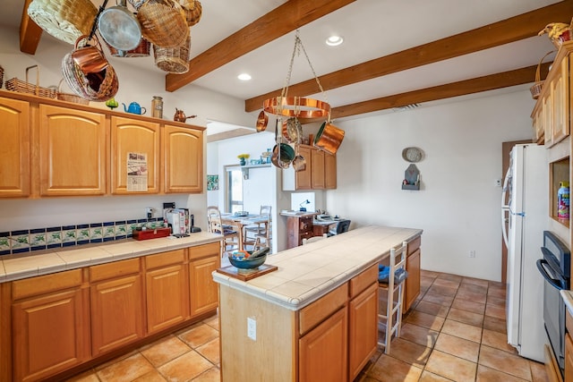 24 Camino Caballos Spur, Lamy, NM 87540 - kitchen with tile counters, beamed ceiling, recessed lighting, a kitchen island, and oven