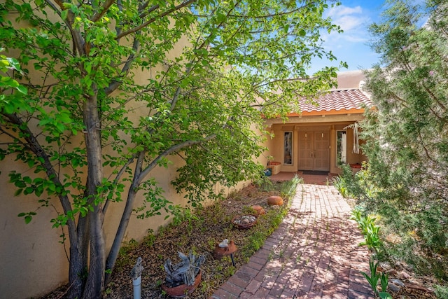 24 Camino Caballos Spur, Lamy, NM 87540 - doorway to property featuring a tiled roof and stucco siding