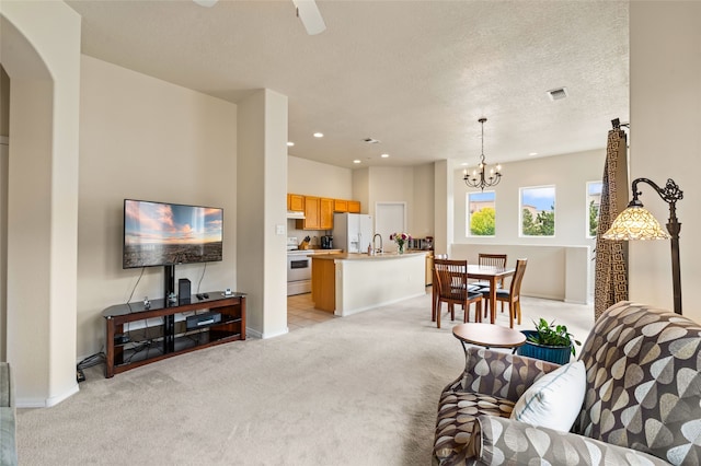 4315 Santo Domingo Unit C, Santa Fe, NM 87507 - living room with light colored carpet, a chandelier, baseboards, arched walkways, and recessed lighting