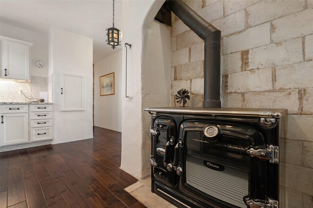 100 Rancho Alegre, Santa Fe, NM 87508 - detailed view of wood finished floors, a wood stove, arched walkways, and decorative backsplash