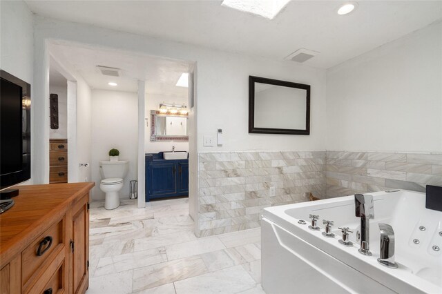 100 Rancho Alegre, Santa Fe, NM 87508 - full bathroom featuring a whirlpool tub, toilet, tile walls, vanity, and recessed lighting
