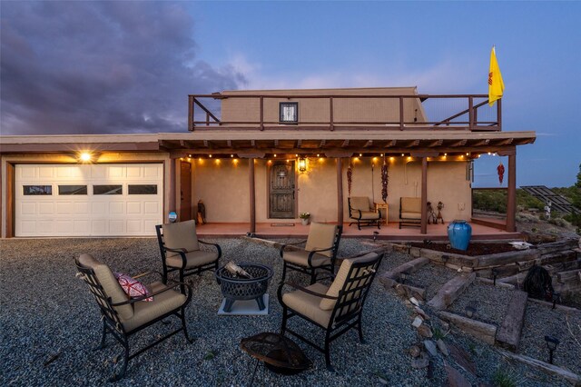 100 Rancho Alegre, Santa Fe, NM 87508 - back of house featuring a fire pit, stucco siding, a patio, an attached garage, and a balcony