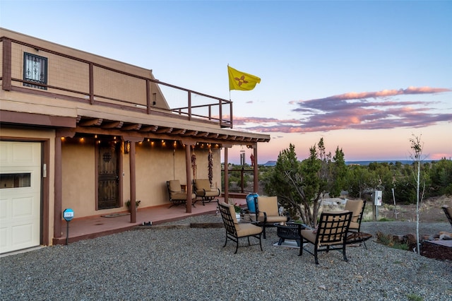 100 Rancho Alegre, Santa Fe, NM 87508 - patio terrace at dusk with an outdoor living space with a fire pit and a garage