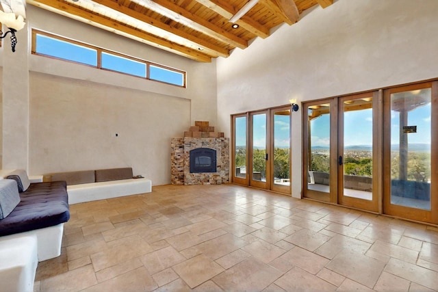5 Camino Sin Ganas, Santa Fe, NM 87506 - unfurnished living room with wooden ceiling, beam ceiling, a towering ceiling, french doors, and stone tile floors