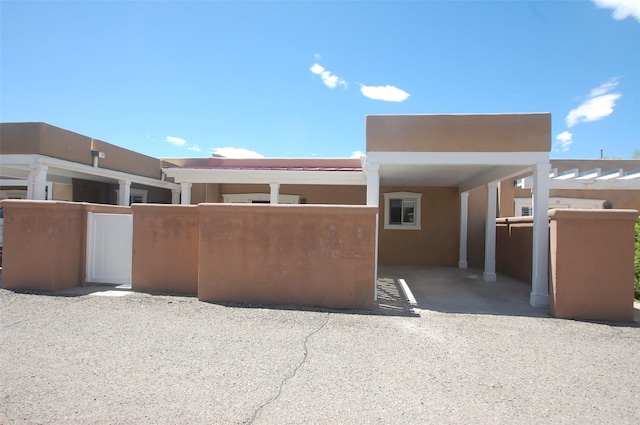 663 Bishops Ldg Unit 64, Santa Fe, NM 87501 - view of front of property featuring stucco siding and fence