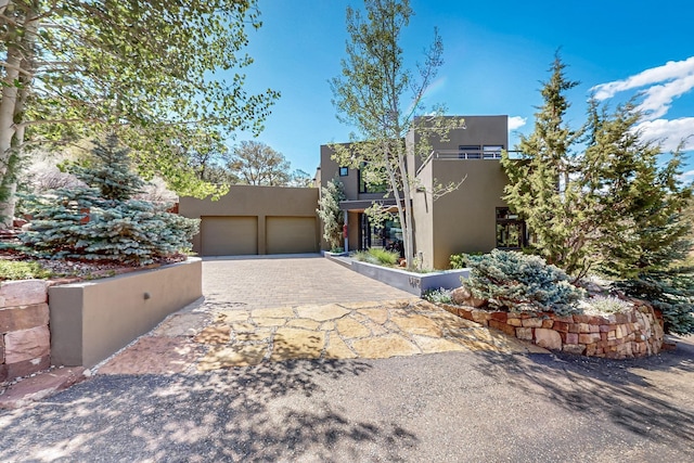 view of front of property with stucco siding, driveway, and a garage
