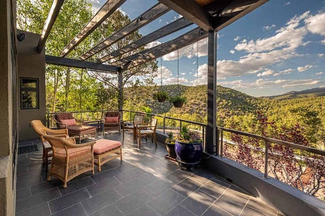 view of patio featuring a pergola, an outdoor living space, and a mountain view