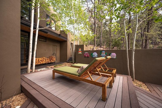 wooden terrace featuring fence and stairs