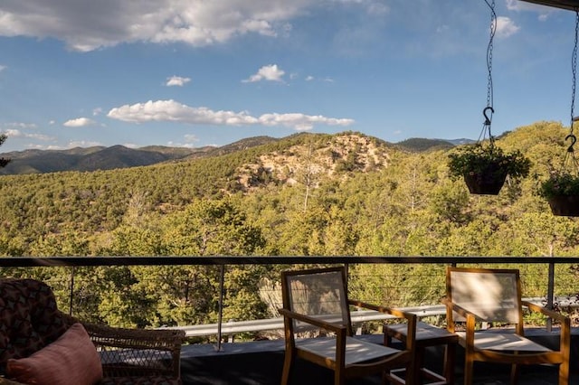 balcony featuring a mountain view and a forest view