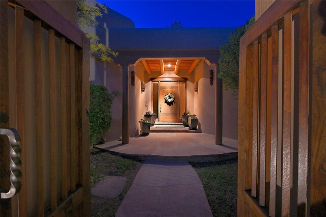 exterior entry at night featuring stucco siding
