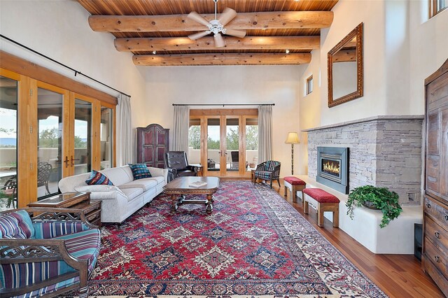 living room featuring french doors, wooden ceiling, a high ceiling, wood finished floors, and beamed ceiling