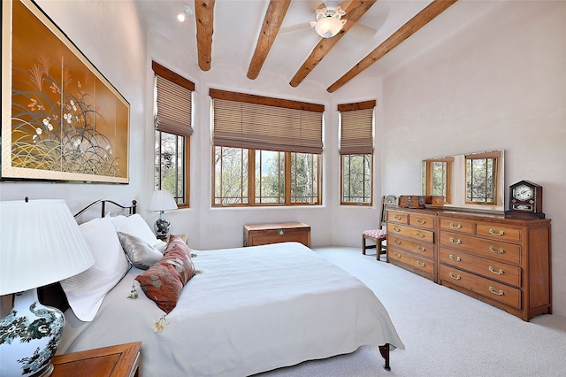 bedroom featuring carpet flooring, beam ceiling, and ceiling fan