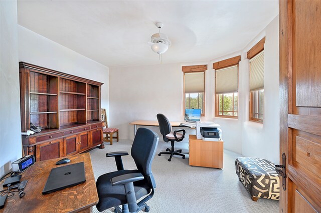 carpeted home office featuring a ceiling fan