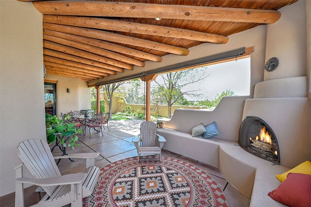 view of patio with outdoor dining area and an outdoor living space with a fireplace