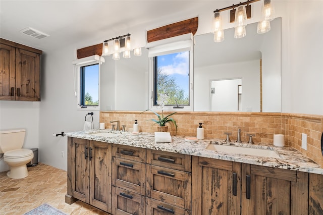 20 San Juan Ranch Rd, Santa Fe, NM 87506 - full bathroom featuring toilet, decorative backsplash, double vanity, and stone finish flooring