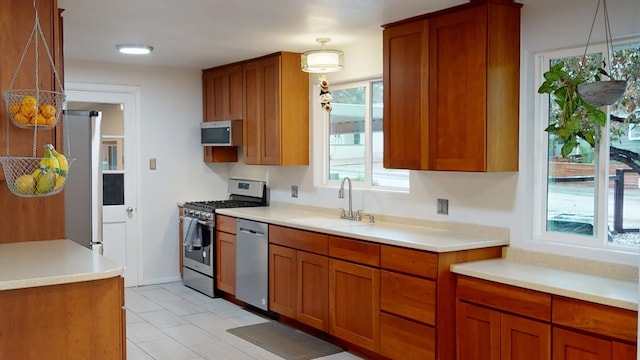 2935 Arizona, Los Alamos, NM 87544 - kitchen with appliances with stainless steel finishes, a sink, brown cabinets, light countertops, and decorative light fixtures