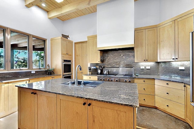 36 Green Meadow Loop, Santa Fe, NM 87506 - kitchen featuring light brown cabinets, decorative backsplash, a kitchen island with sink, dark stone counters, and high vaulted ceiling