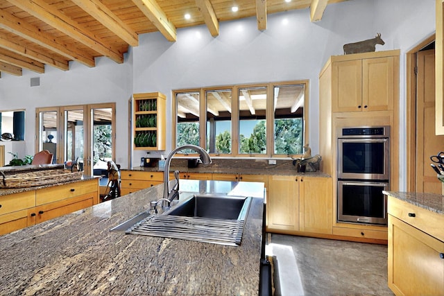 kitchen featuring stainless steel double oven, wooden ceiling, light brown cabinetry, beamed ceiling, and a sink