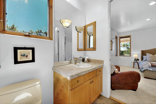 ensuite bathroom featuring vanity, toilet, and recessed lighting