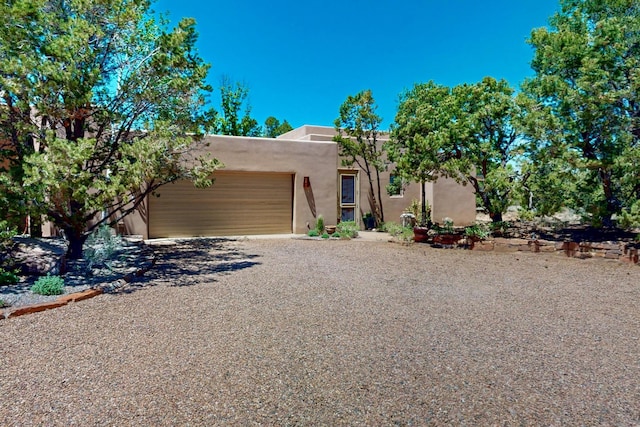 36 Green Meadow Loop, Santa Fe, NM 87506 - southwest-style home featuring a garage, stucco siding, and gravel driveway