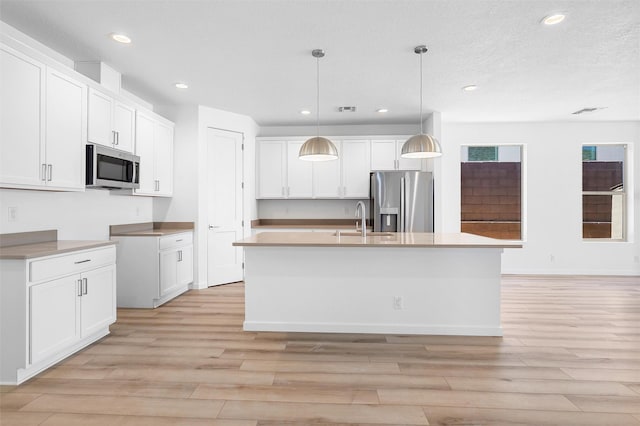 137 Mirador Blvd, Los Alamos, NM 87547 - kitchen with stainless steel appliances, a sink, light wood-style flooring, recessed lighting, and an island with sink