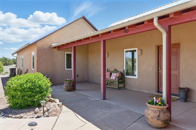 34 Ranch Rd, Lamy, NM 87540 - rear view of property with stucco siding, a patio area, metal roof, and a standing seam roof