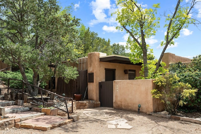 928 Los Lovatos Rd, Santa Fe, NM 87501 - view of front of property with a gate, fence, and stucco siding