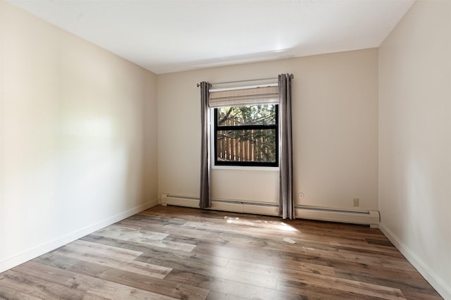 928 Los Lovatos Rd, Santa Fe, NM 87501 - unfurnished room featuring wood finished floors, a baseboard heating unit, and baseboards