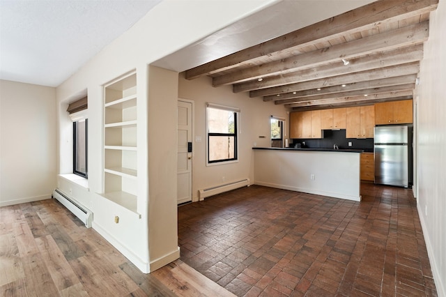 928 Los Lovatos Rd, Santa Fe, NM 87501 - kitchen featuring freestanding refrigerator, baseboard heating, a peninsula, dark countertops, and beamed ceiling