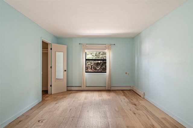 928 Los Lovatos Rd, Santa Fe, NM 87501 - unfurnished bedroom featuring wood finished floors, baseboards, and baseboard heating