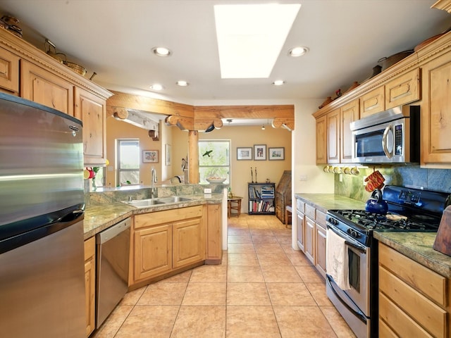 54 Encantado Loop, Santa Fe, NM 87508 - kitchen with appliances with stainless steel finishes, a sink, a peninsula, a skylight, and recessed lighting
