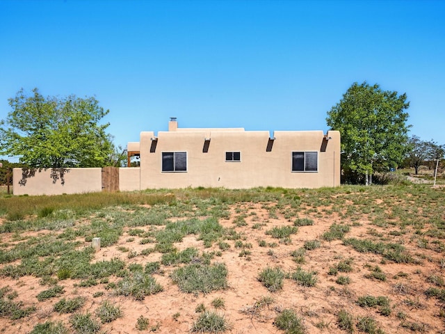 54 Encantado Loop, Santa Fe, NM 87508 - back of property featuring stucco siding and a chimney