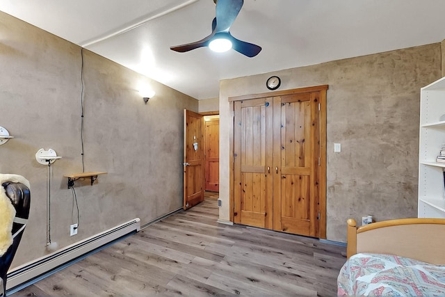 26 Apache Creek Rd, Santa Fe, NM 87505 - bedroom with a baseboard heating unit, wood finished floors, and a ceiling fan