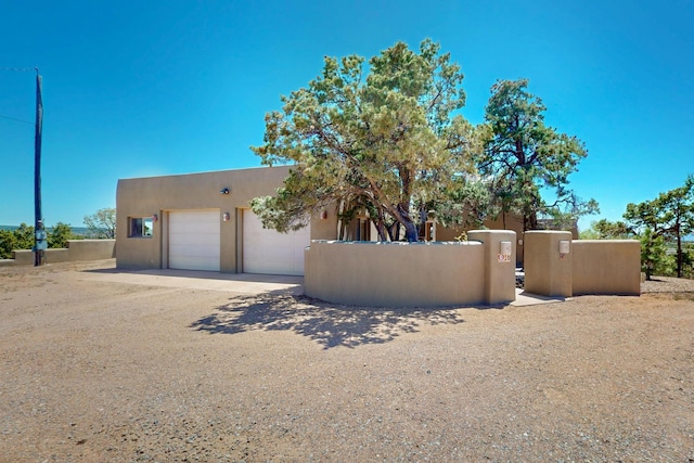 26 Apache Creek Rd, Santa Fe, NM 87505 - pueblo revival-style home featuring stucco siding, fence, and a gate