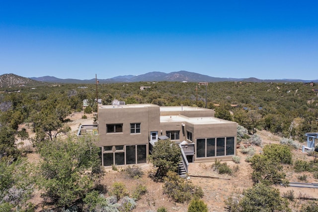 26 Apache Creek Rd, Santa Fe, NM 87505 - view of front of house featuring stucco siding, a mountain view, a sunroom, and stairs