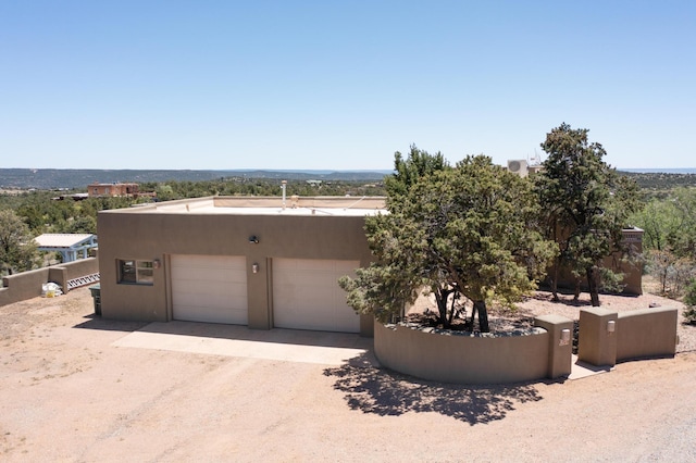26 Apache Creek Rd, Santa Fe, NM 87505 - view of front of property with stucco siding, driveway, and a garage