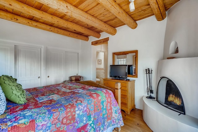 334 Otero Unit 14-3, Santa Fe, NM 87501 - bedroom with light wood-style flooring, wooden ceiling, beam ceiling, multiple closets, and connected bathroom